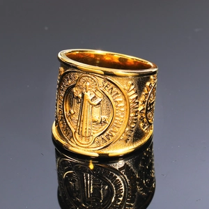 Macro shot of gold St. Benedict medal ring with detailed relief and Latin engraving