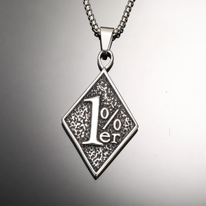 Vue macro du pendentif losange argenté gravé 1%er avec une finition texturée