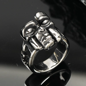 Macro shot of vintage stainless steel ring with abstract mask relief and dark texture