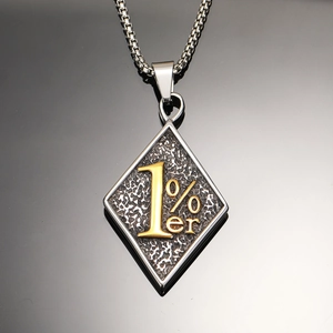 Détail d'un pendentif losange 1%er vintage avec texte doré sur une chaîne à maillons