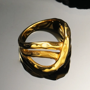 Détail macro de la texture lave irrégulière sur une bague multicouche en acier titane doré