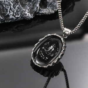 Detailed close-up of a silver elephant pendant necklace with oval black relief design