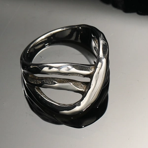 Gros plan d'une bague multicouche irrégulière en acier titane avec une finition argentée polie