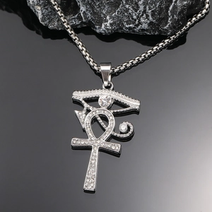 Detailaufnahme des Ankh-Kreuz Anhängers mit Augenmotiv und funkelnden Kristallen