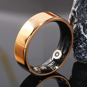 Macro shot of gold smart ring with internal health sensors and charging contacts