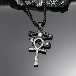 Makroaufnahme von schwarzem Ankh-Anhänger mit Horusauge und glitzernden Strasssteinen
