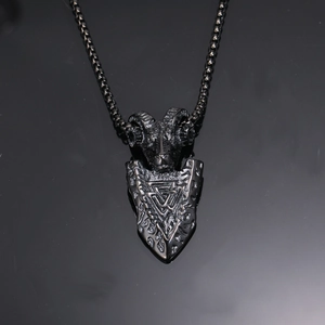 Détail macro du pendentif bouclier tête de bélier Viking sur fond réfléchissant noir