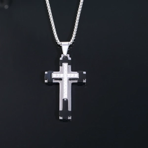 Détail macro du pendentif croix bicolore avec oxydes de zirconium sur chaîne box