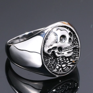 Vista macro del rilievo di teschio e gabbia toracica su anello punk in acciaio argento