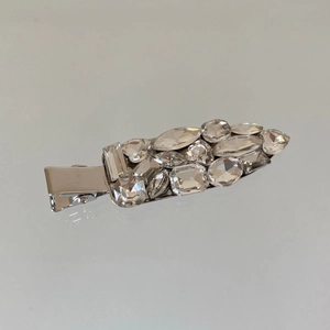 Détail d'une pince à cheveux en forme de feuille avec strass brillants et alliage argent