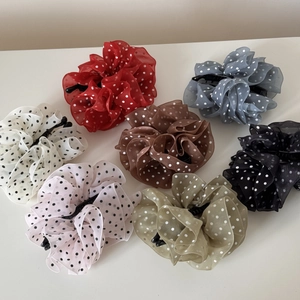 Flat lay of seven colorful polka dot chiffon hair claws showing pleated fabric texture