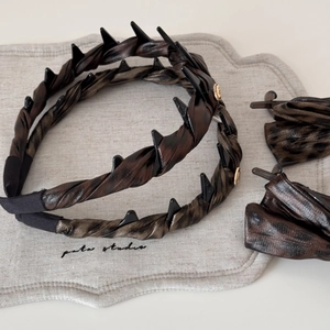 Close-up of tortoise print hair accessories set with golden accents and textured fabric
