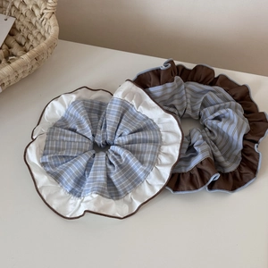 Detailed view of oversized blue striped and checkered scrunchies with scalloped lace edges