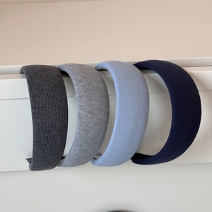 Primo piano di quattro cerchietti larghi in maglia grigio e blu con trama a costine