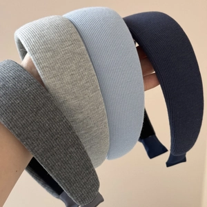 Dettaglio di quattro fasce per capelli in maglia spessa grigie e blu con trama a costine