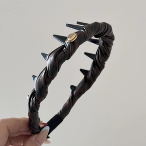 Detail view of the deep brown twisted fabric headband with an oval gold love buckle