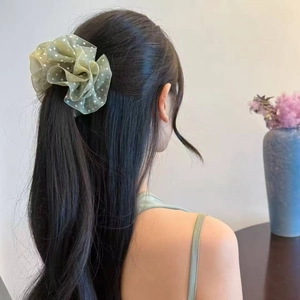 Detail of green organza polka dot hair scrunchie styled on a ponytail back view