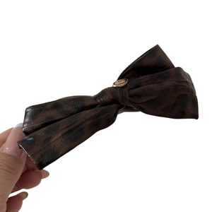 Faux leather bow hair clip with tortoiseshell leopard pattern and gold love buckle