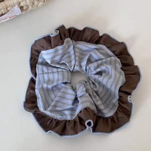 Close-up of dual-layer ruffled scrunchie in coffee brown and blue striped fabric