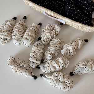 Nahaufnahme eleganter gepunkteter Bananen-Haarspangen aus weißem und schwarzem Chiffon