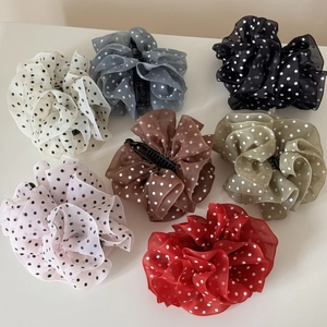 Detailed top view of chiffon polka dot hair claws in seven assorted elegant colors