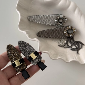 Macro detail of rhinestone tassels and vintage floral hair clips with pearl accents