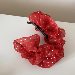 Detail of red mesh banana hair clip with white polka dots and elegant ruffled layers