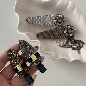 Detail of luxury rhinestone tassel hair clips with dark gems and pearl border