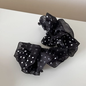 Detail of multi-layered black polka dot mesh fabric on a stylish banana hair clip