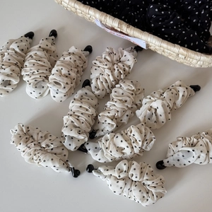 Detail von cremefarbenen Bananen-Haarklammern mit schwarzen Punkten im Korb
