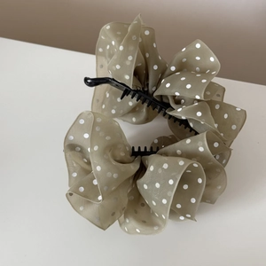 Detail of elegant polka dot chiffon banana hair clip showing layered fabric and texture