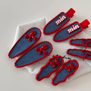 Retro denim hair clips set with red bows and white min letters on a white display pad