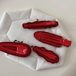 Detailed back view showing metal spring clip structure of 4-piece red hair clip set