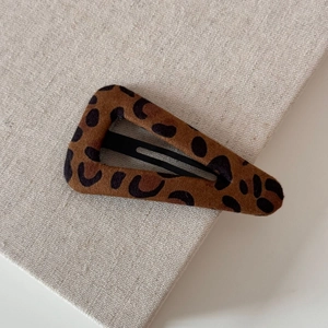 Detailed macro view of the triangular leopard print hair clip with soft flocked texture