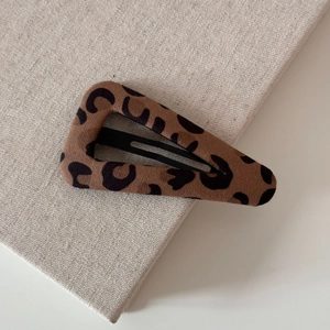 Detailed view of the leopard print fabric texture on a high-quality snap hair clip