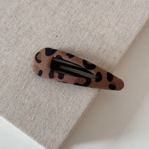 Close-up of leopard print hair clip with soft flocking texture and black metal BB base
