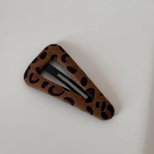 Close-up of vintage leopard print hair clip with brown velvet texture and matte metal base