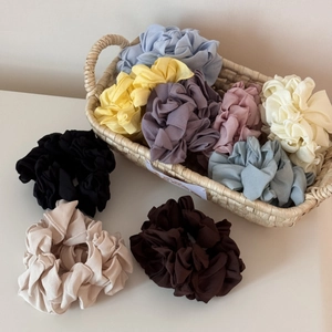 Gros plan détaillé de chouchous plissés colorés dans un panier et sur fond blanc pur