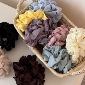 Lot de chouchous plissés en mousseline colorée dans un panier pour coiffure élégante