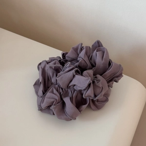 Détail de l'élastique à cheveux plissé violet poudré avec volants en tissu dense