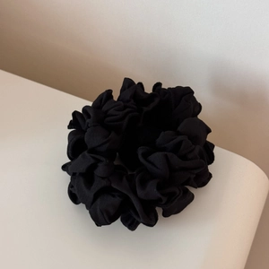 Vue détaillée de la texture fine du tissu et du design plissé du chouchou noir