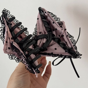 Detail of satin polka dot hair claw clip with black lace trim and polished inner structure