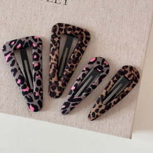 Primo piano di quattro fermagli per capelli BB leopardati nei toni marrone e grigio