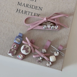 Barrettes à cheveux à nœud rose élégantes avec strass et perles sur fond texturé