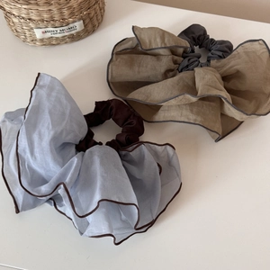 Detailed view of oversized layered tulle scrunchies in blue and coffee floral tones