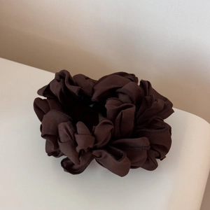 Gros plan d'un chouchou plissé marron foncé avec une texture élégante en mousseline