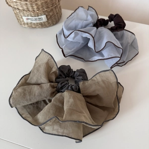 Close-up of oversized organza scrunchies with contrasting edges in blue and green