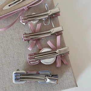 Vue détaillée du dos des barrettes à nœud rose montrant les pinces crocodile en métal