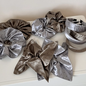 Detailed view of handmade polka dot satin hair scrunchies and headbands in coffee and grey