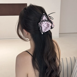 Detailed view of pink satin polka dot bow hair claw with lace and pearl accents